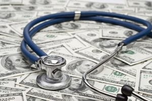 Stethoscope on top of dollar bills
