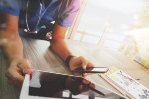 Medical staff working with different electronic devices